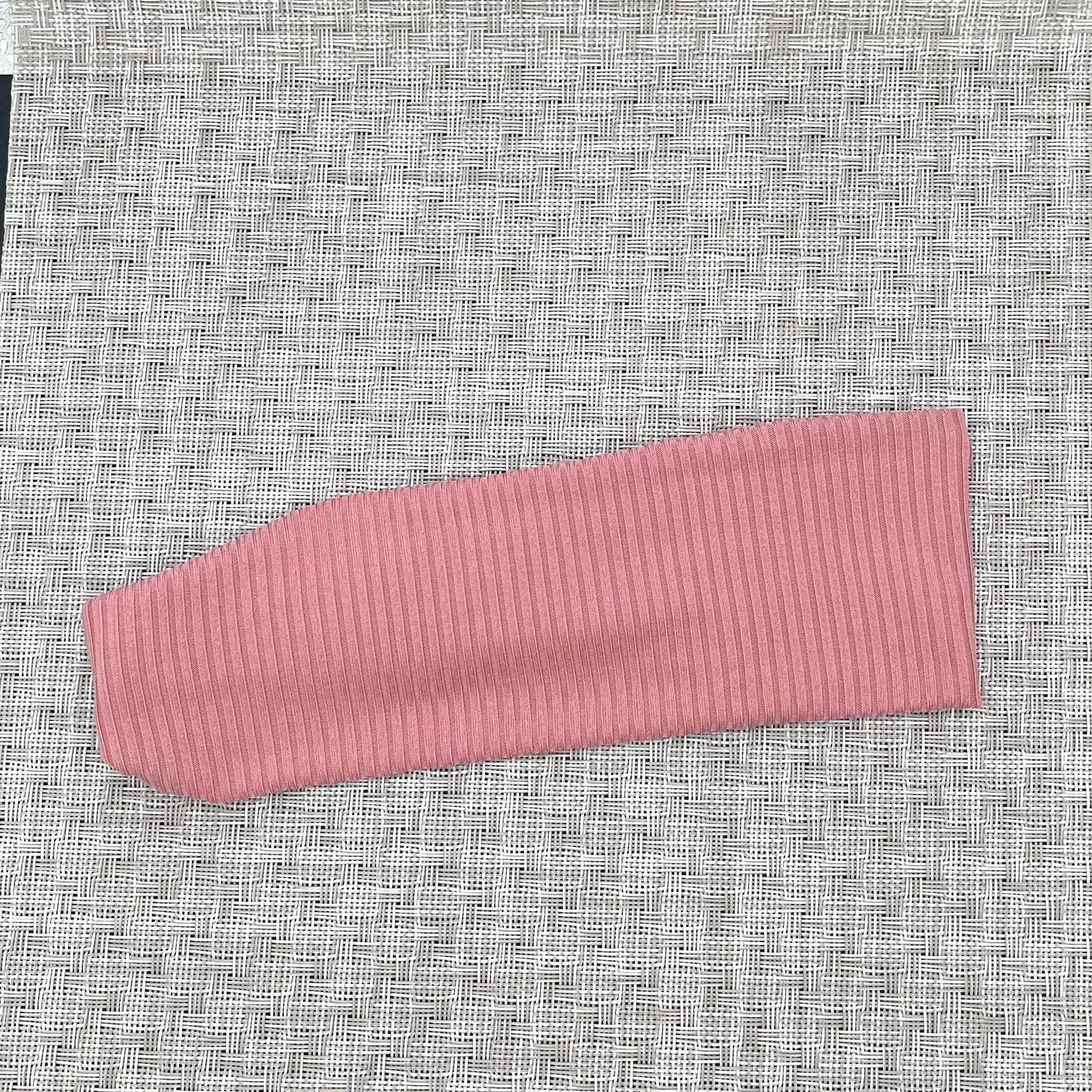 Flat, stretchy, pink ribbed headband.