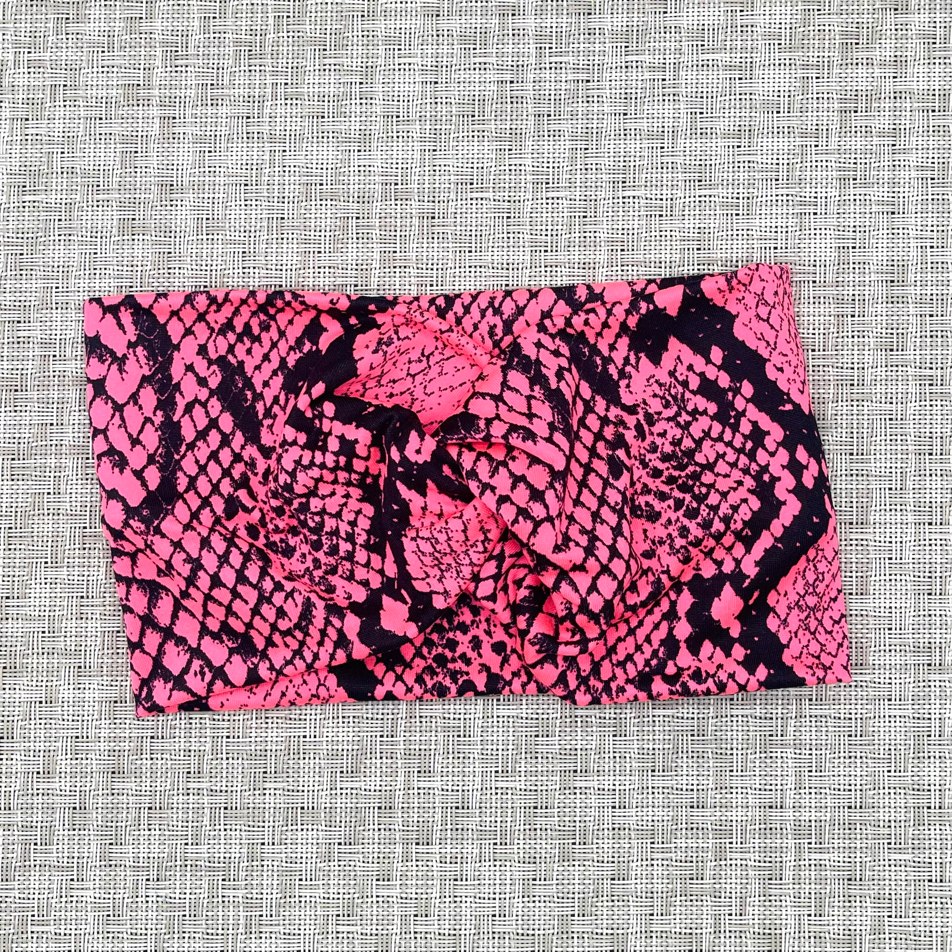 Wide, twisted headband in hot pink with black snakeskin print.