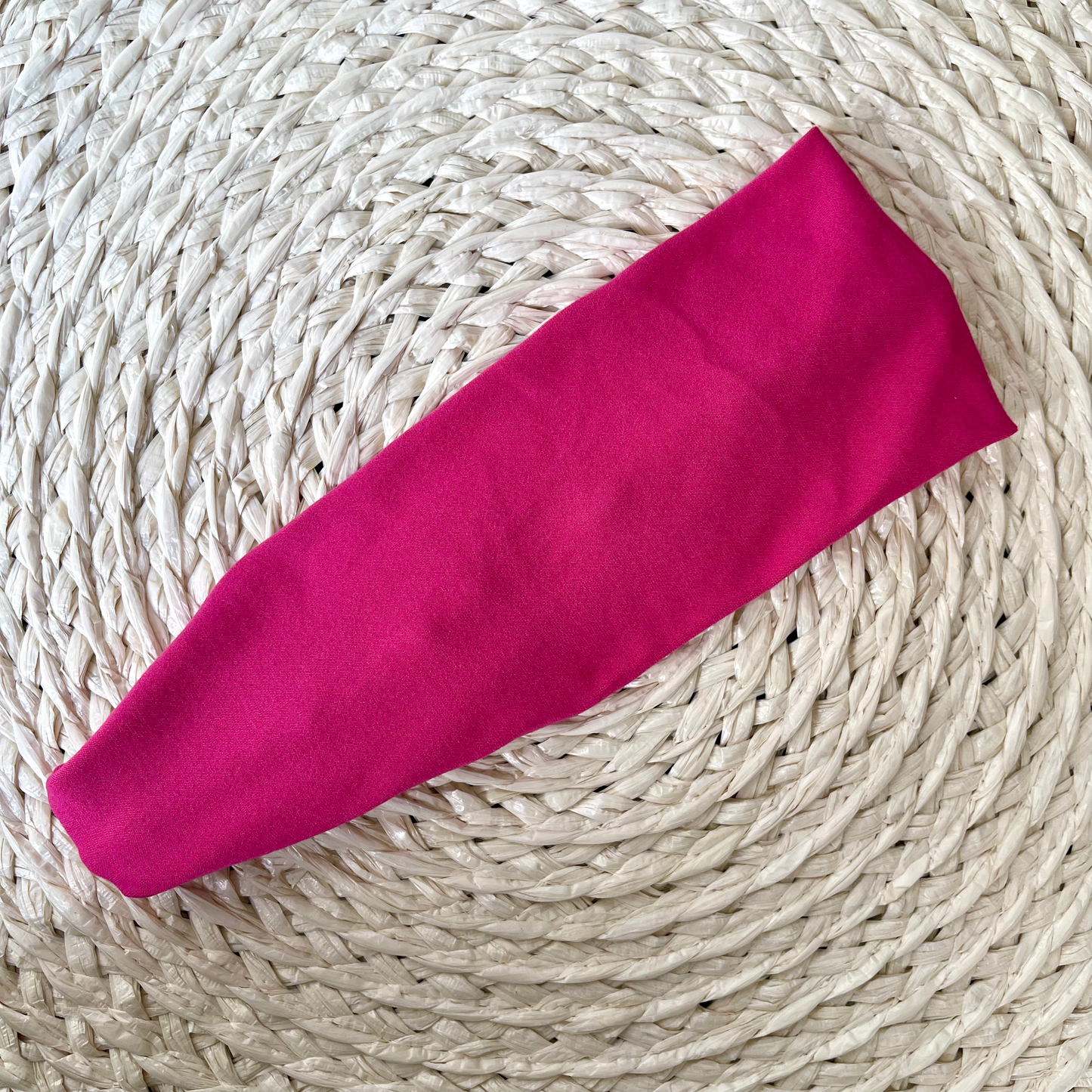 Flat, stretchy, bright pink headband.