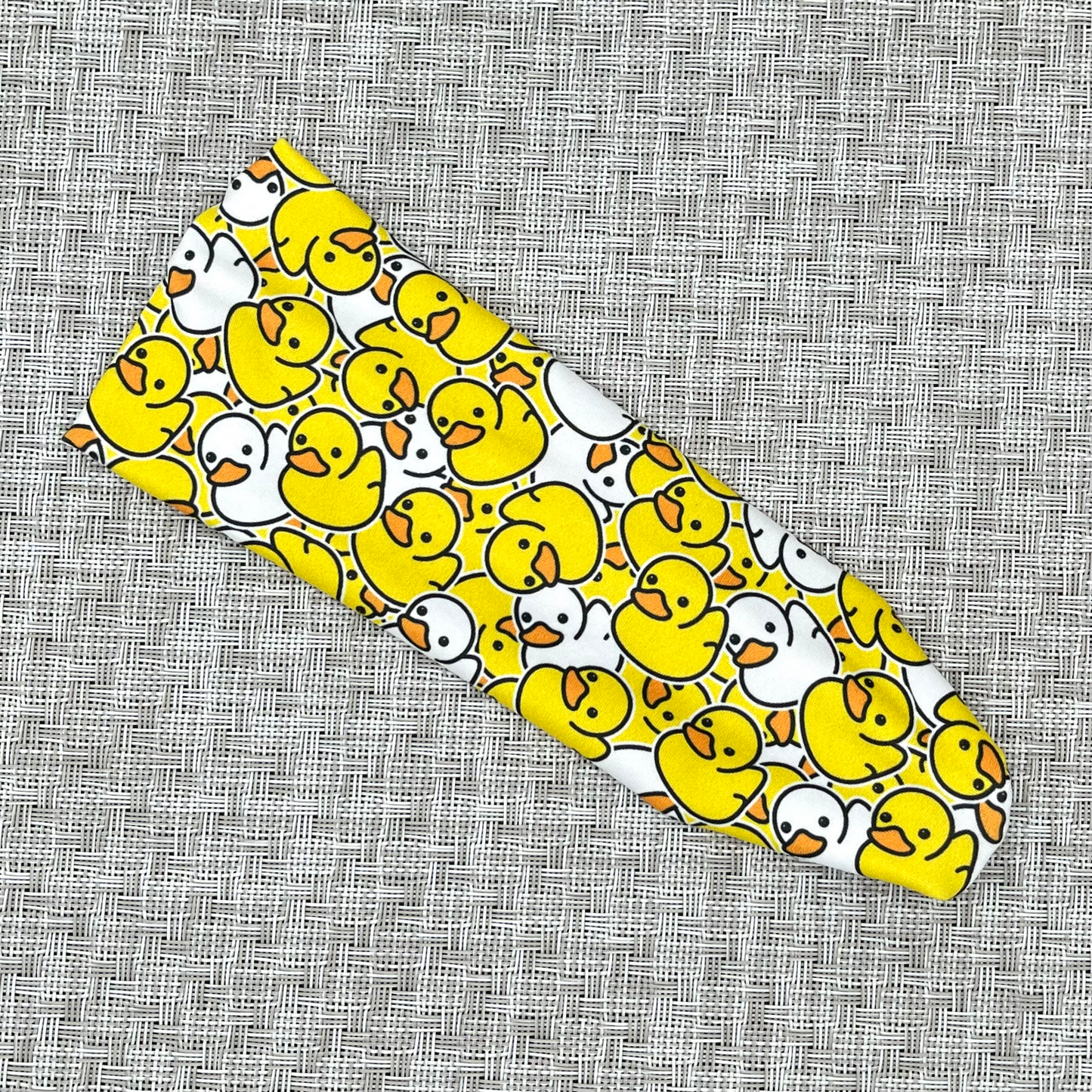 Stretchy headband in yellow and white rubber duck print.