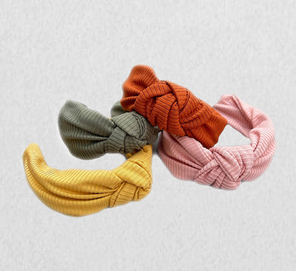 Top knot, hard headbands in varying colors- mustard yellow, light pink, olive green, and burnt orange.