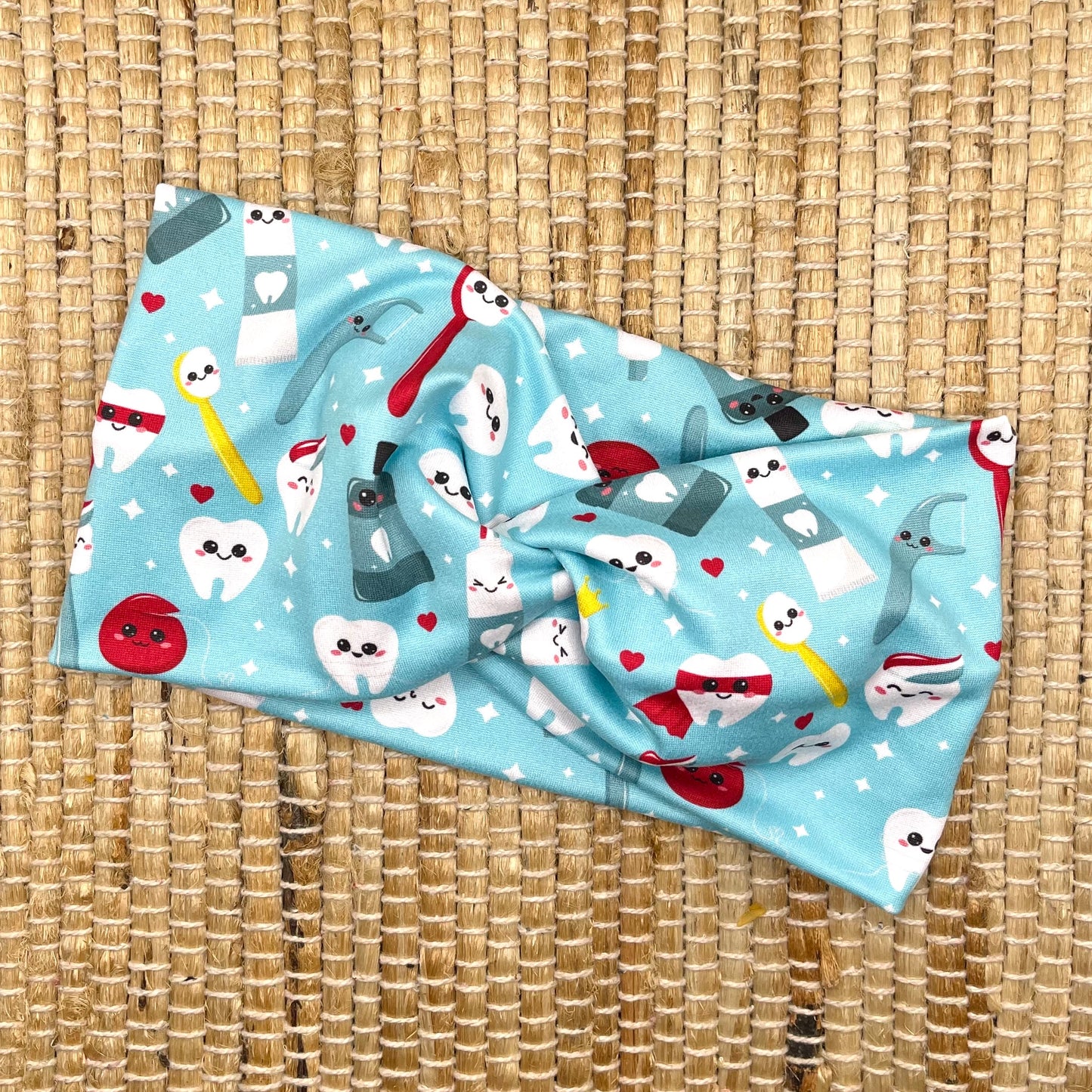 Wide, twisted headband in light blue with dental theme print.