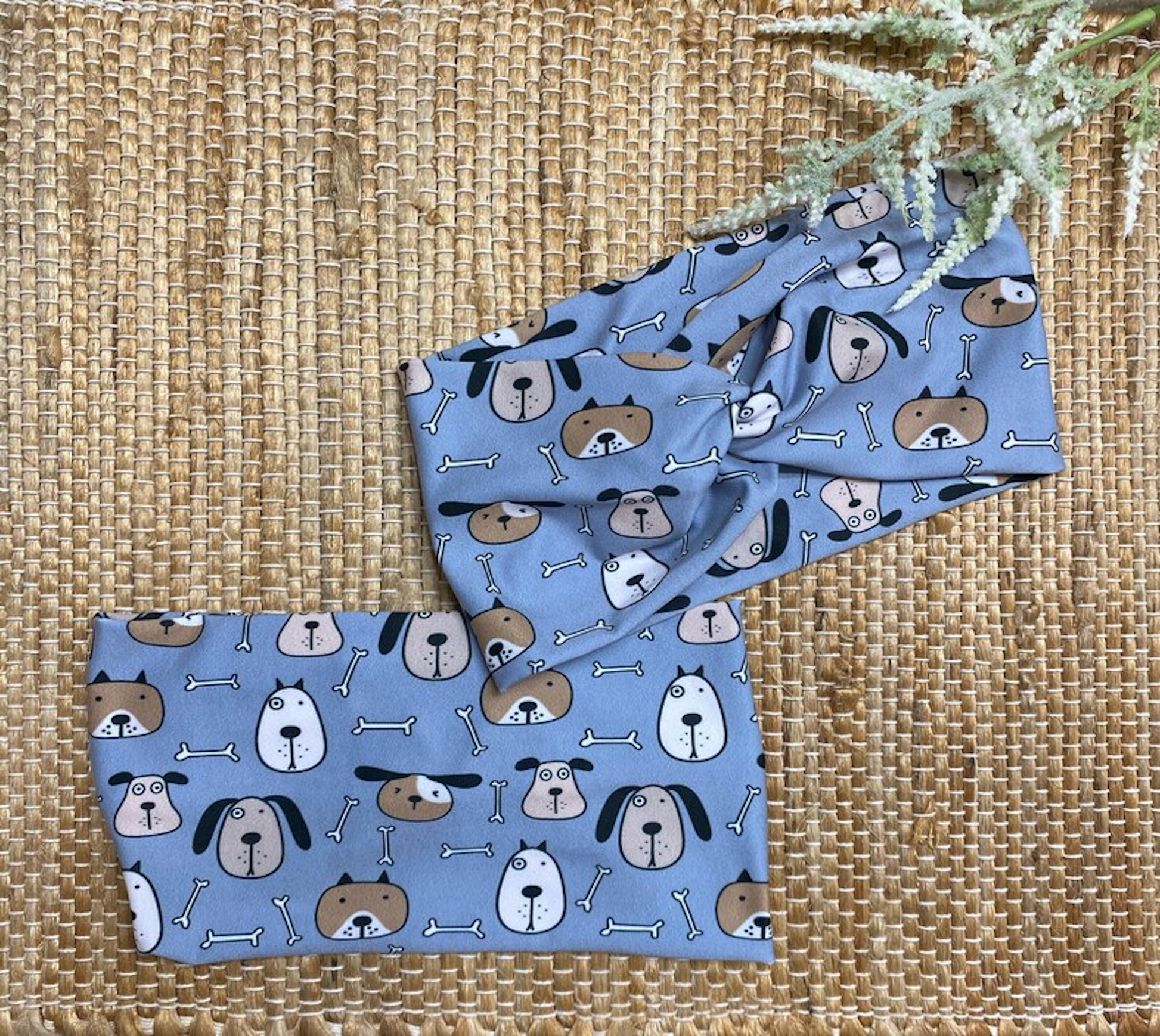 Wide, twisted headband in blue with dog print on a brown background.