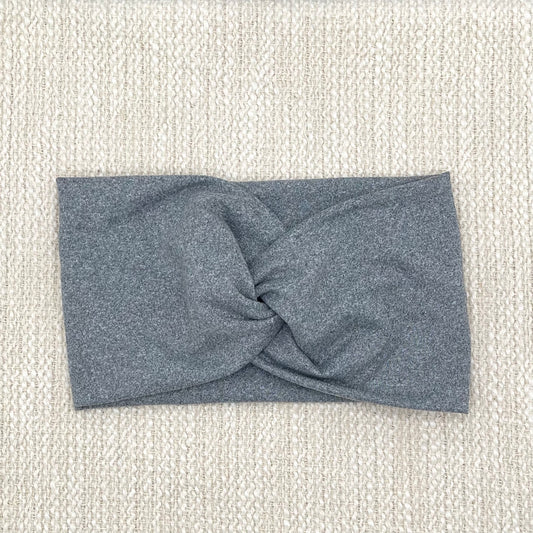 Wide, stretchy, twisted, heather gray color headband on cream color background.