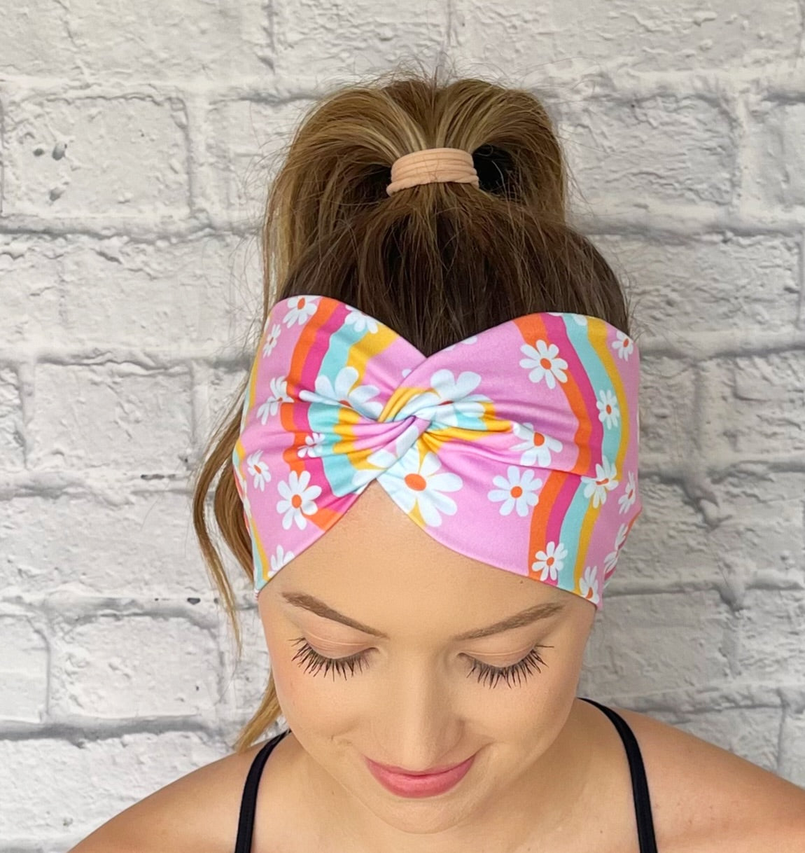 pink headband with yellow, blue, orange, and pink swirls with white flowers