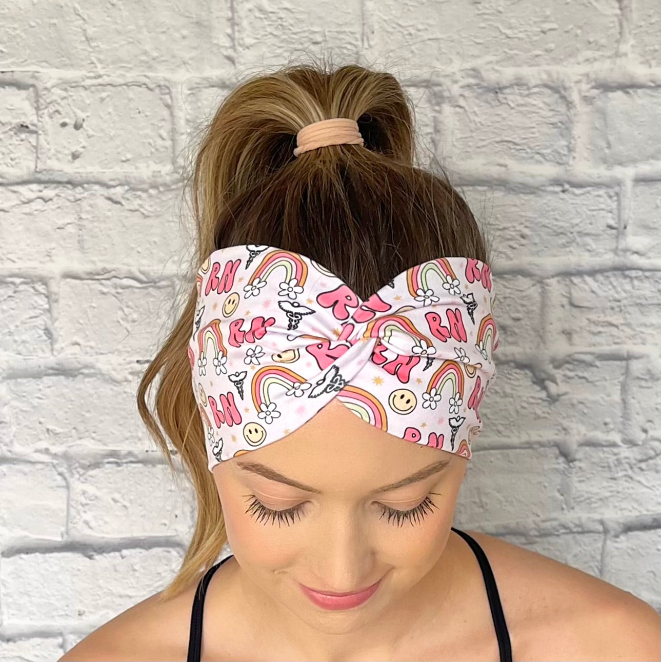 pink headband with "RN", rainbows, flowers, and smiley faces