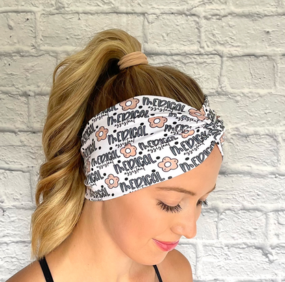 white headband with "medical assisstant", flowers, and polka dot print in blue and tan