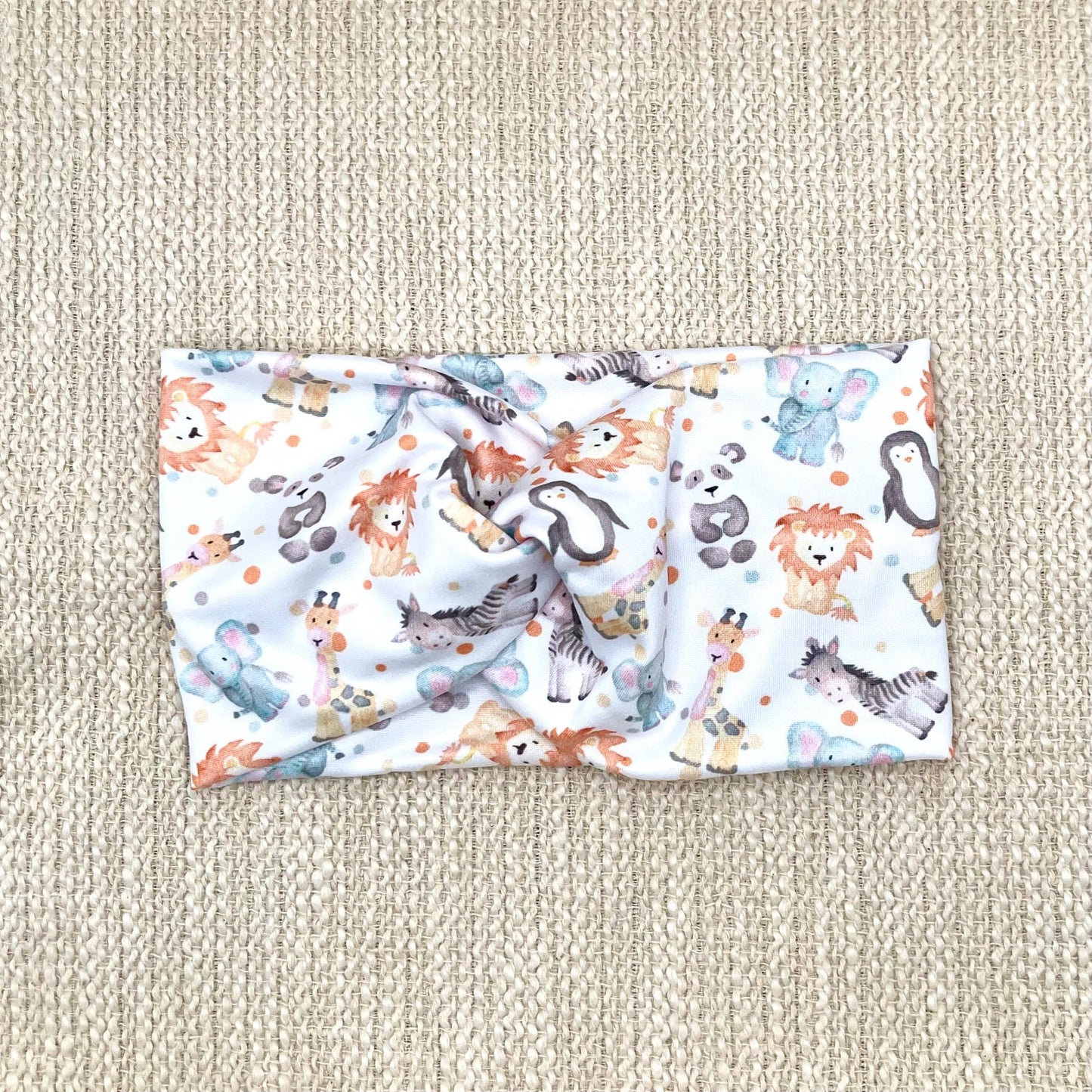 Wide, twisted headband in white with baby animal and polka dot print.