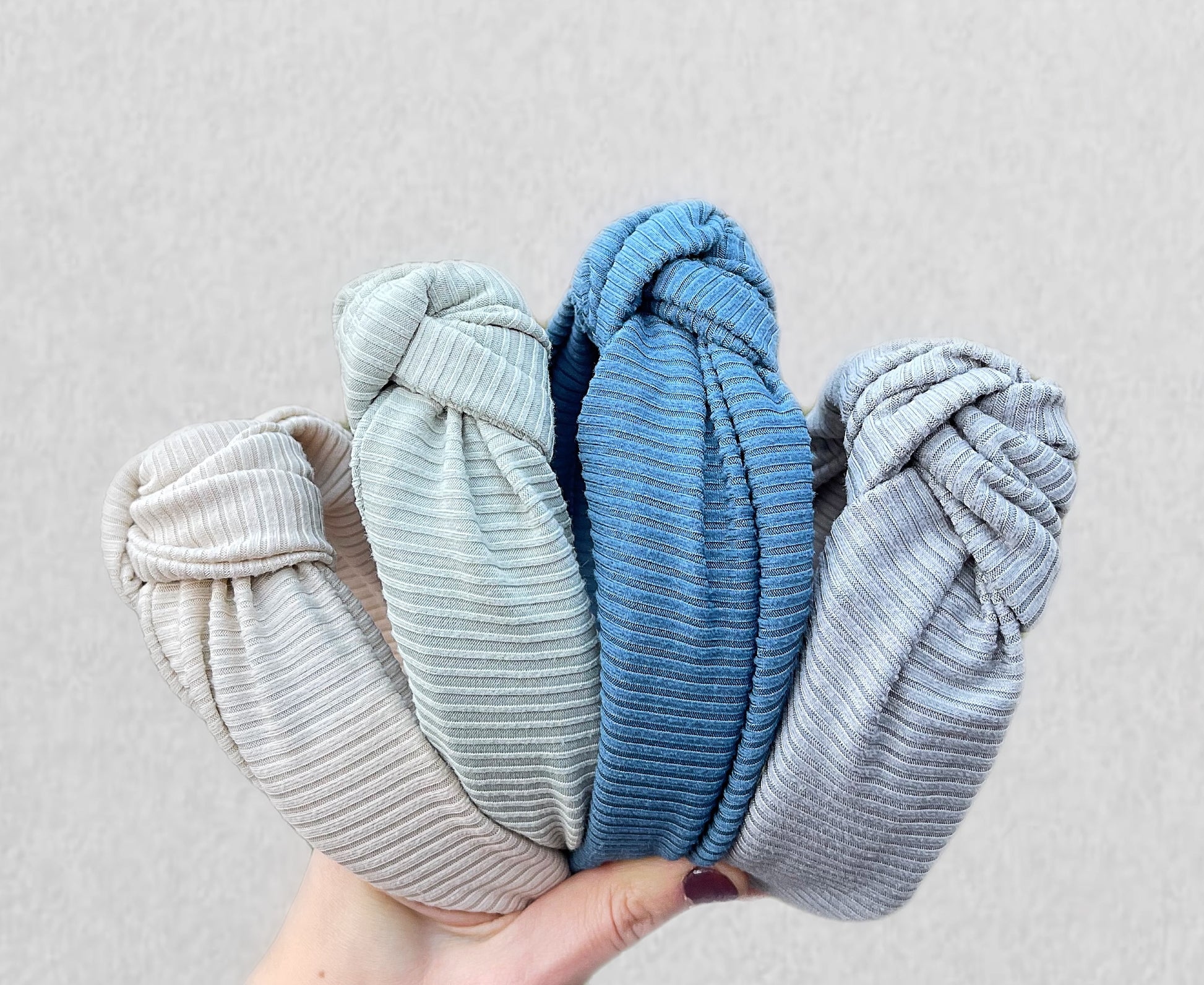 Ribbed, top knot hard headbands in varying colors- cream, sage green, blue, and gray.