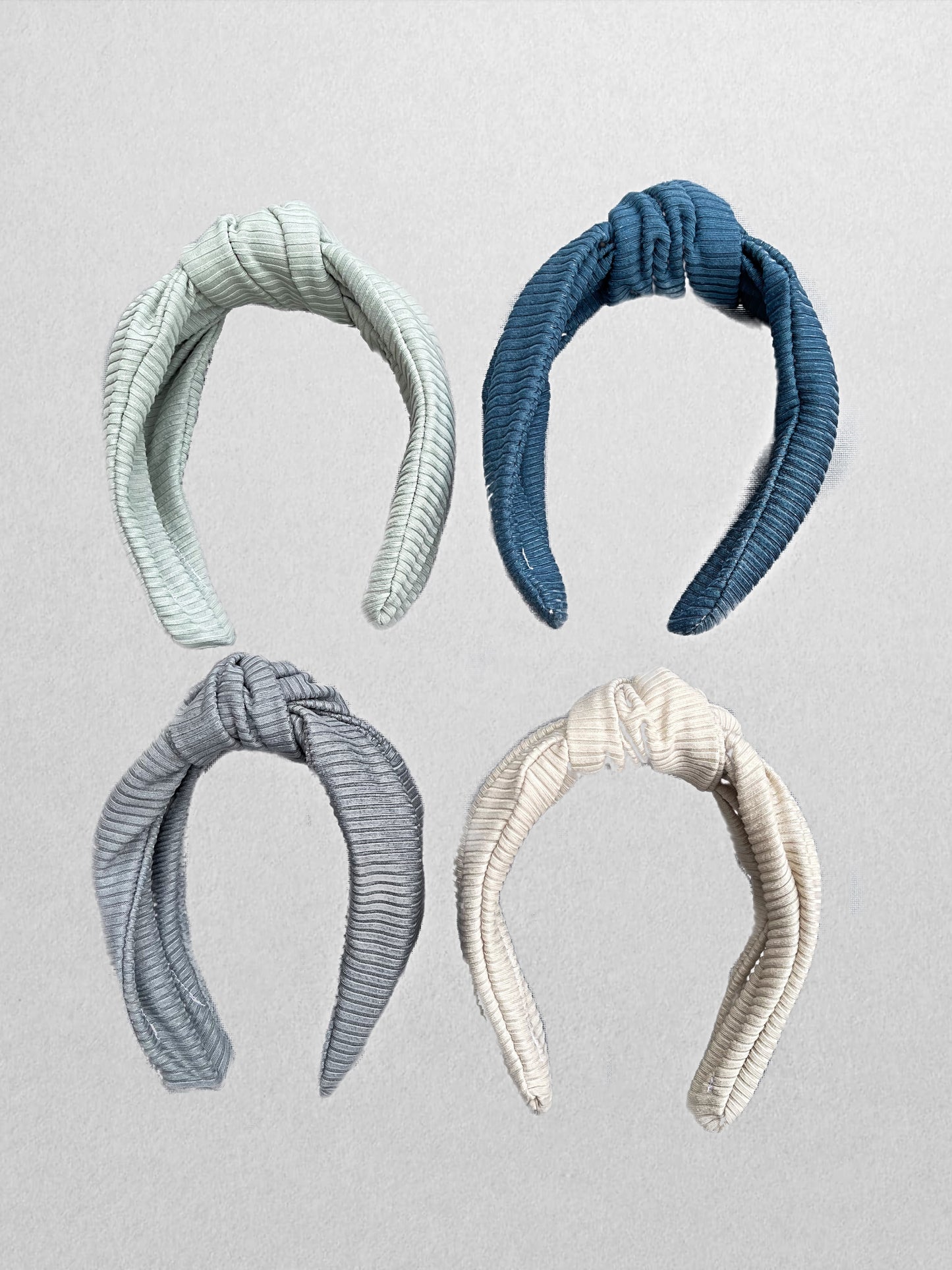 Ribbed, top knot hard headbands in varying colors- cream, sage green, blue, and gray.