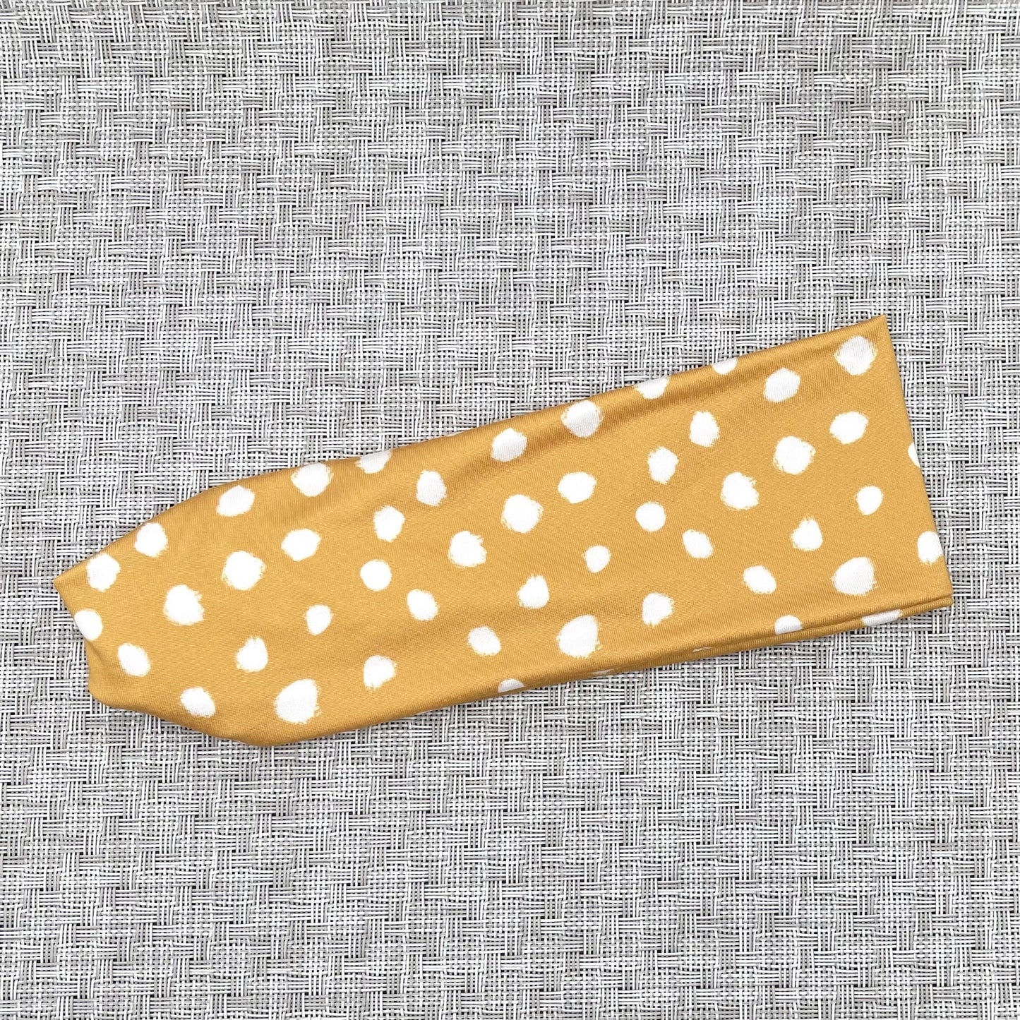 gold color headband with white spotted print