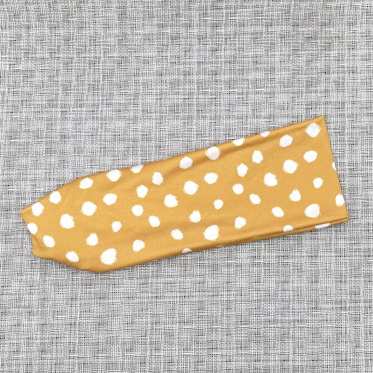 gold color headband with white spotted print