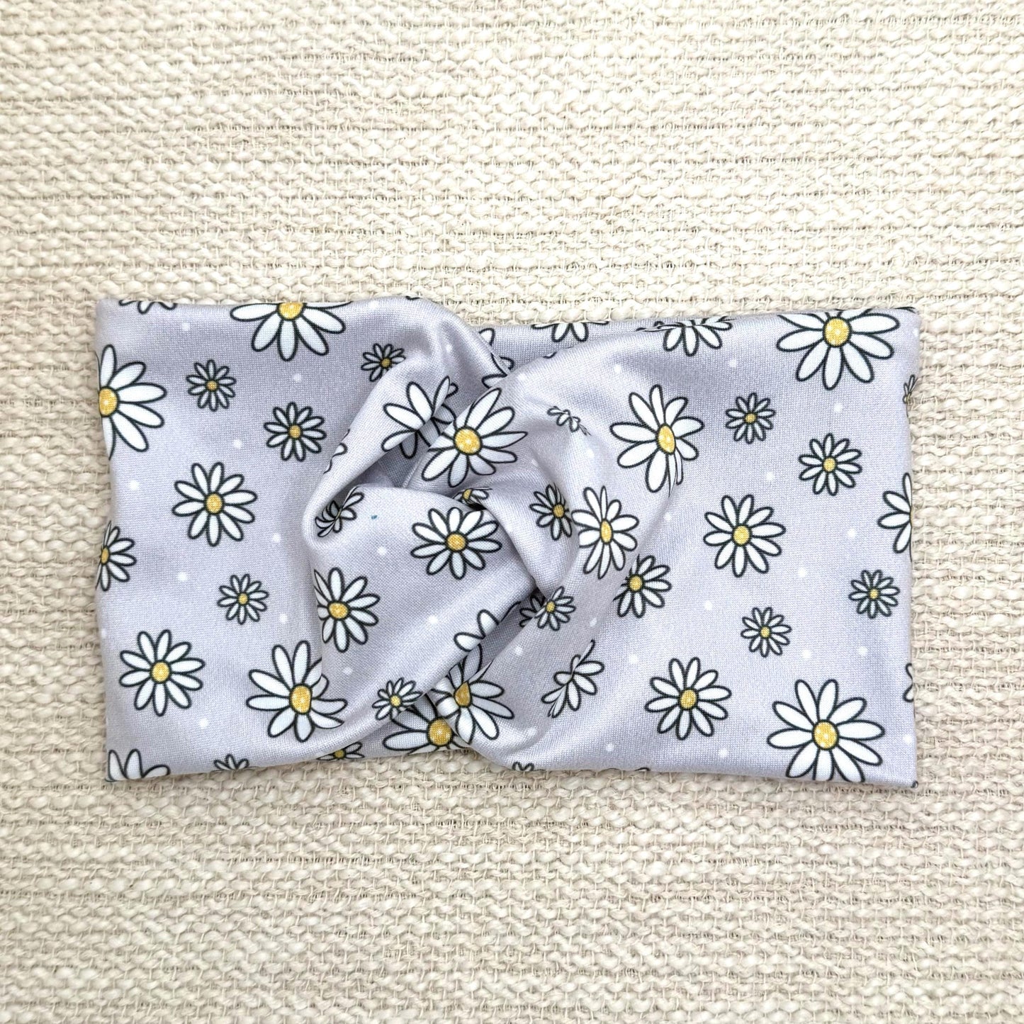 Wide, twisted headband in gray with white daisy print.
