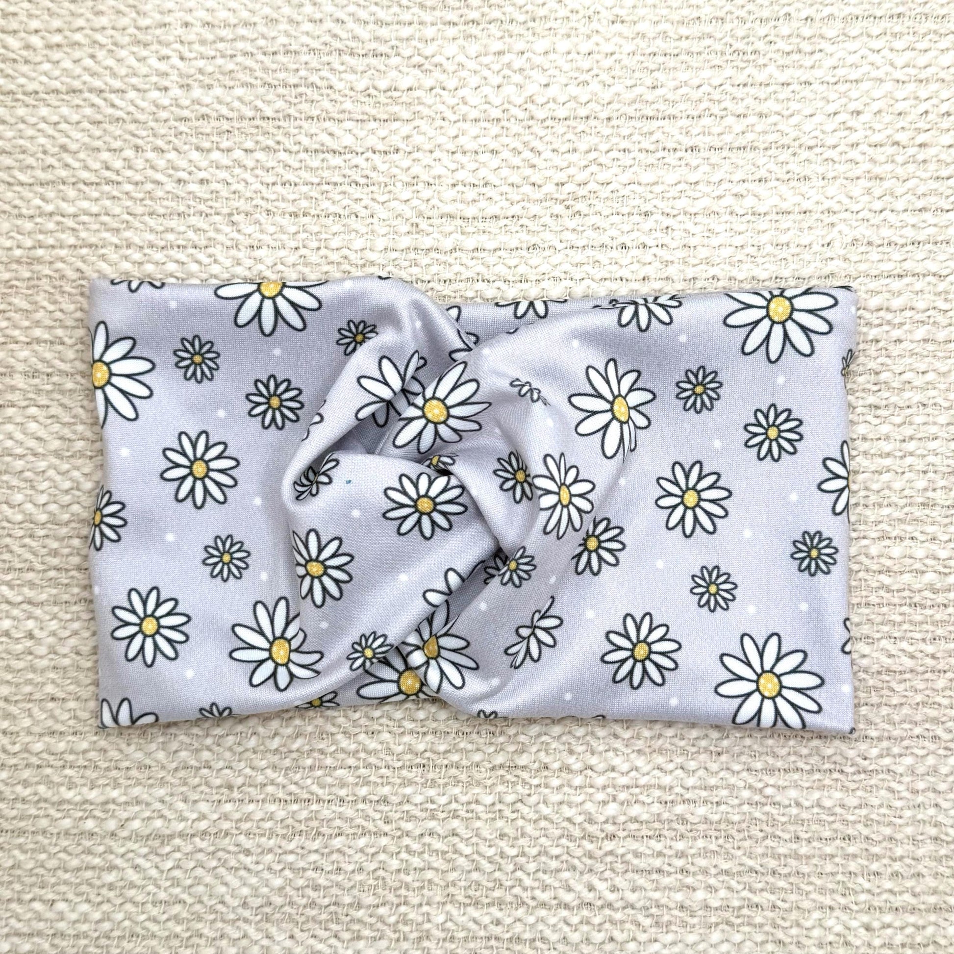 Wide, twisted headband in gray with white daisy print.