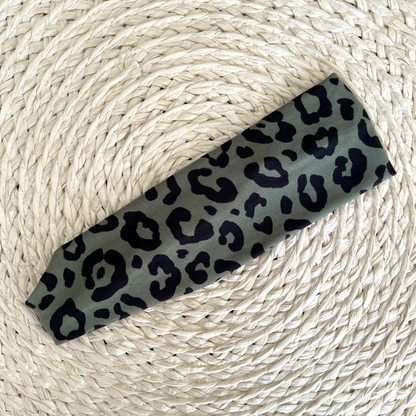 Flat, stretchy, green headband with black cheetah print.