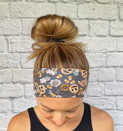 Woman with hair in bun wearing flat, stretchy, gray headband with halloween theme print