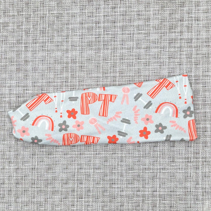 light blue/gray headband with "PT" print in orange and PT theme print with flowers in dark gray/blue and orange