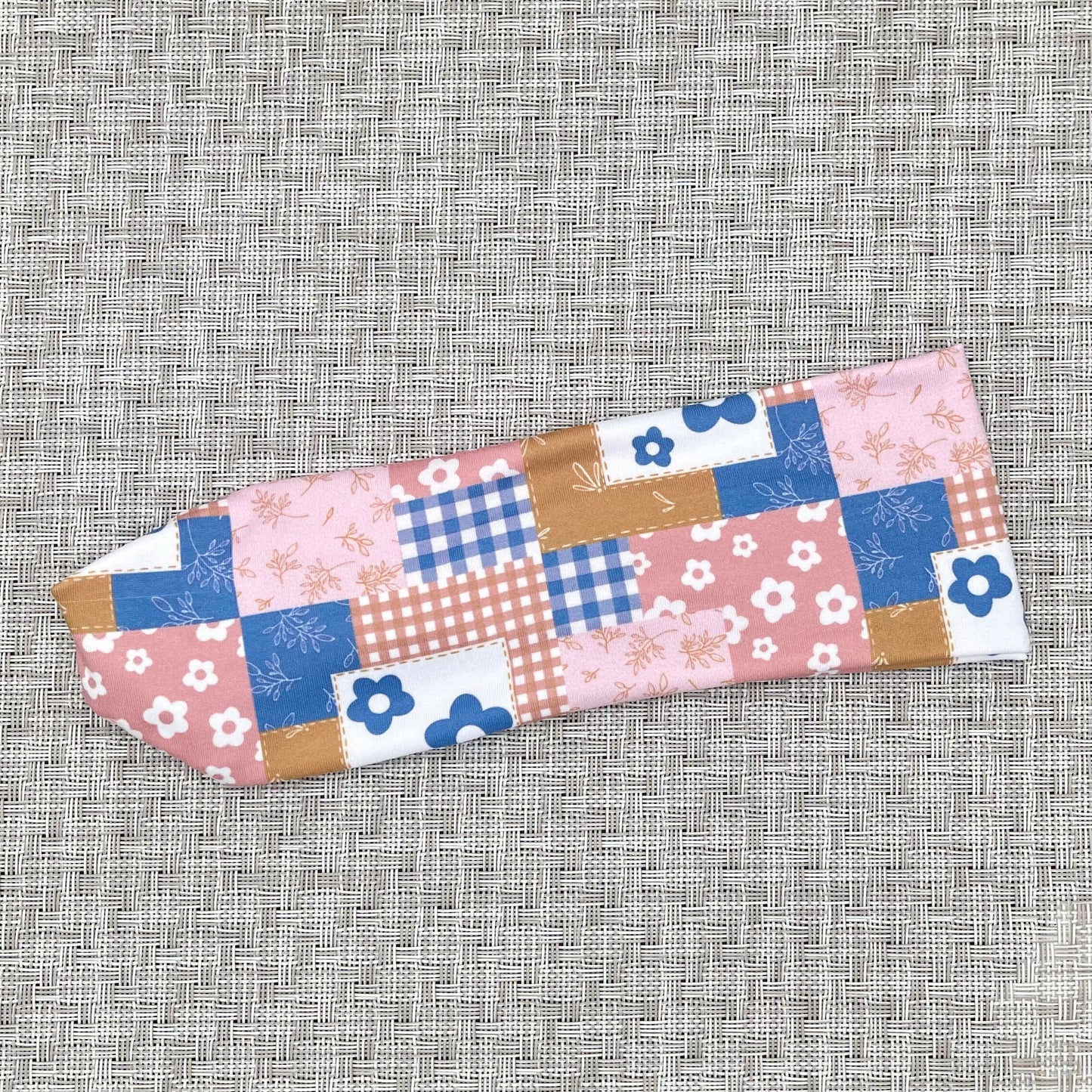 Pink and  blue quilted pattern headband. Contains checker print with plaid, flowers, and checkers