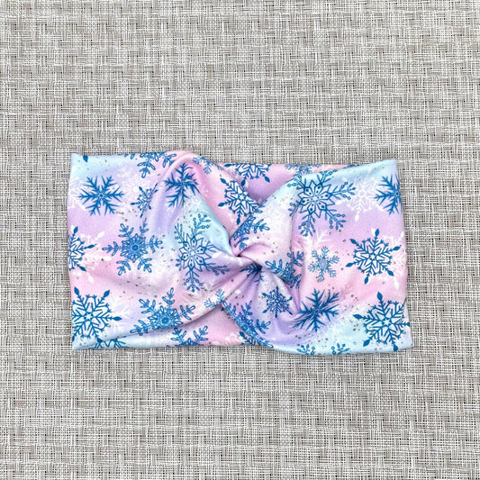 Wide, twisted headband with blue, purple, and pink color with blue and white snowflake print.