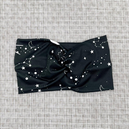 Wide, twisted headband in black with white galaxy theme print.