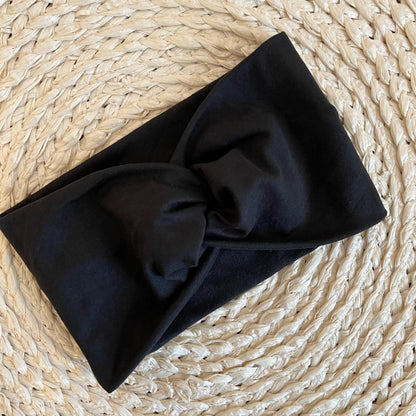 Woman wearing black, wide twisted stretchy headband.