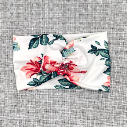 Wide, twisted headband in white with red/pink rose print.