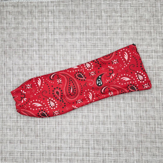 Soft, stretchy, flat headband in red bandana print on a gray background.