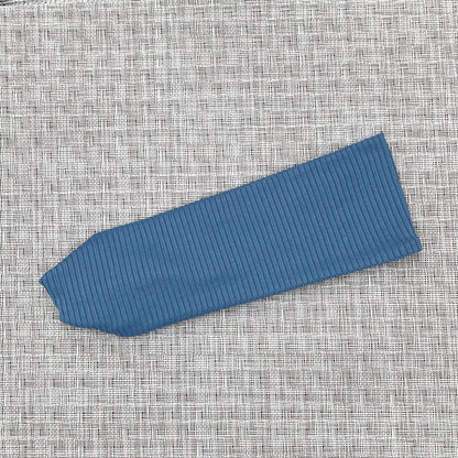 Flat, stretchy headband in blue ribbed fabric.