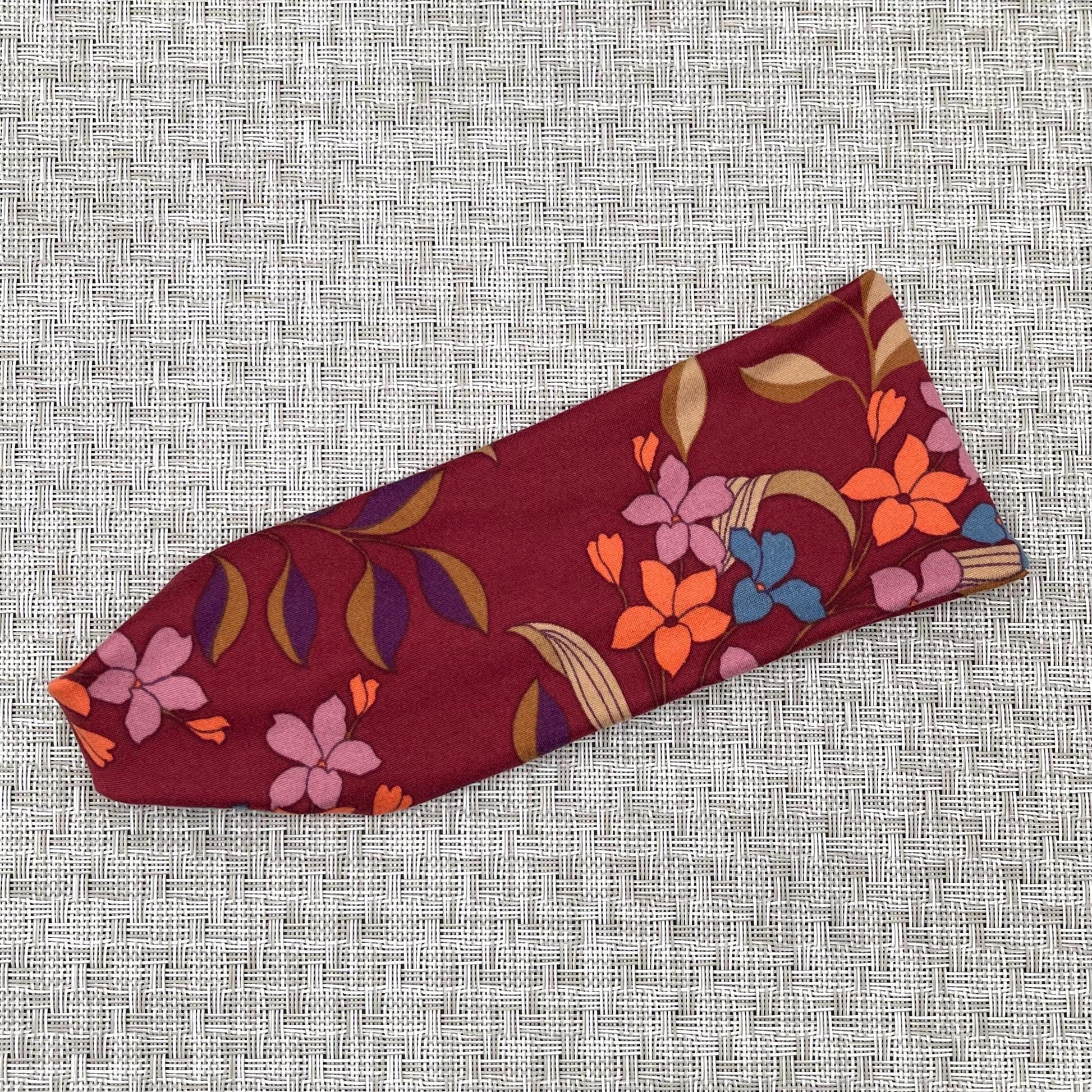 Flat, stretchy headband in maroon with floral print.