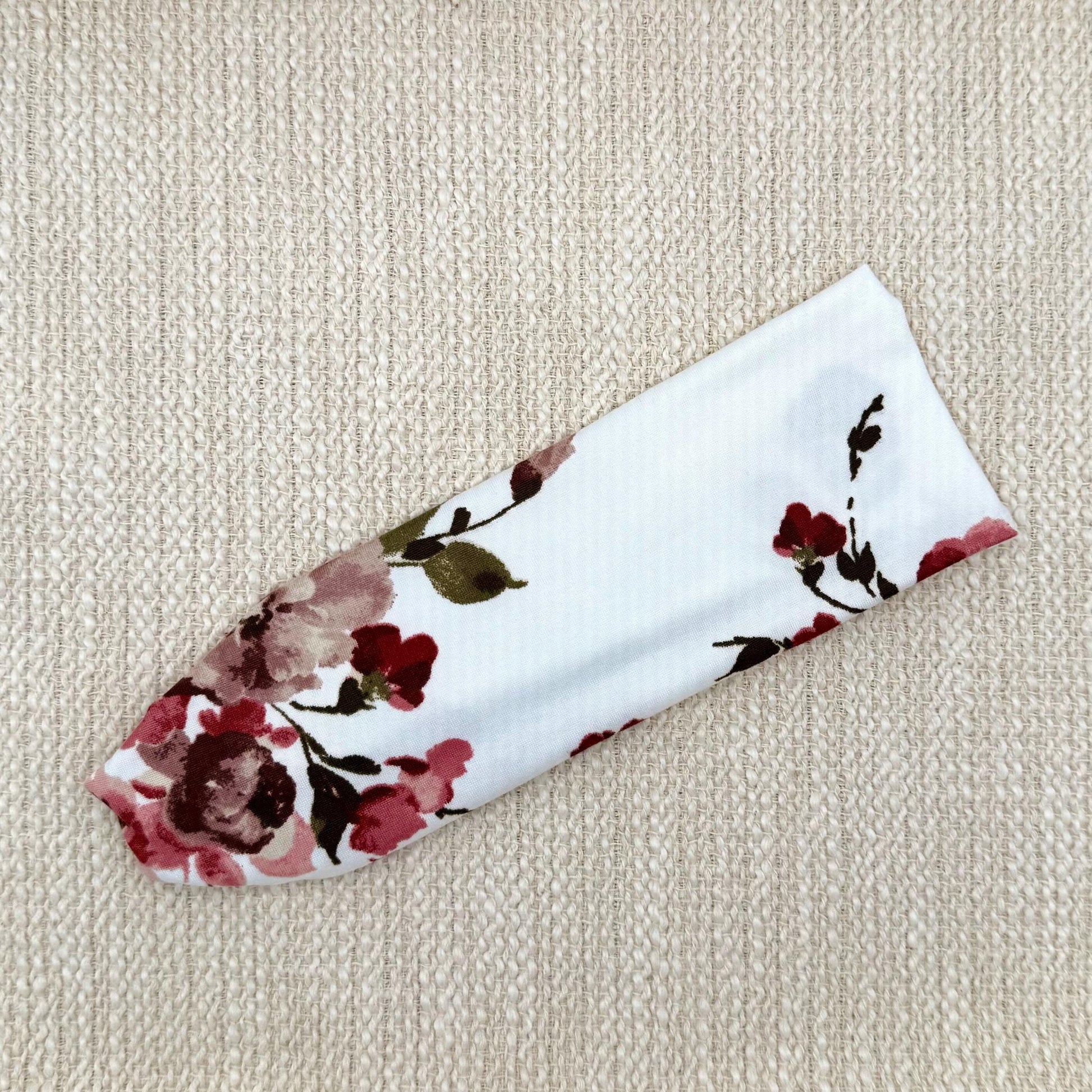 Flat, stretchy headband in white with maroon rose print.