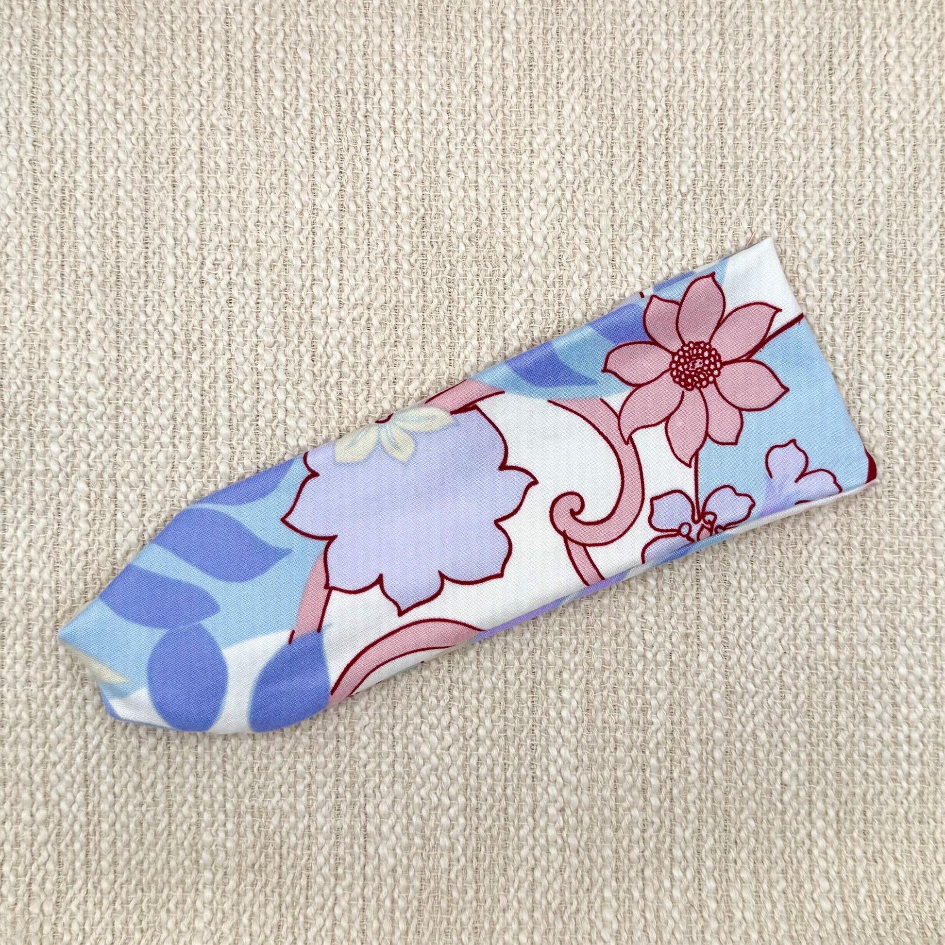 Flat, stretchy headband in lavender, light blue, pink, and white floral print.