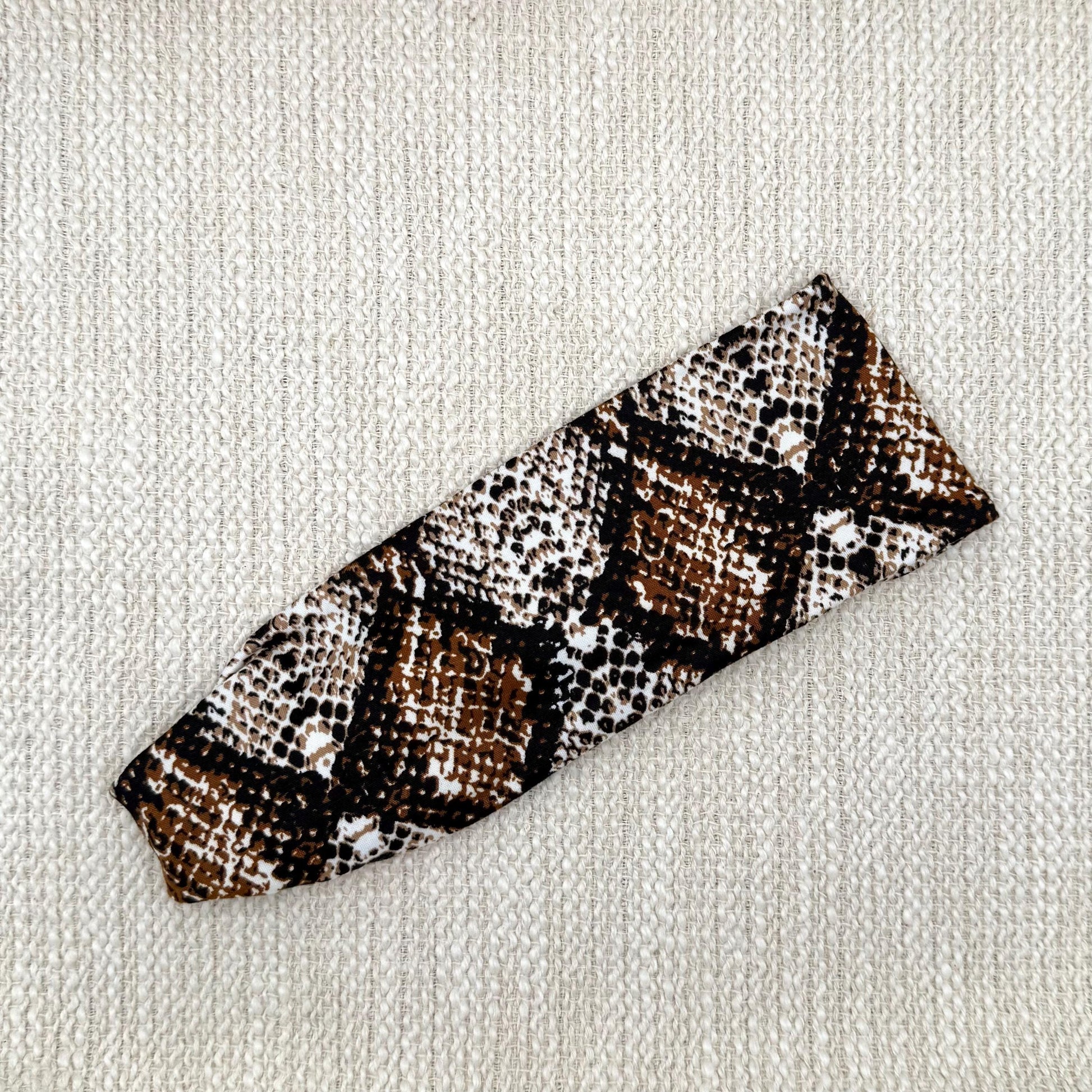 Flat, stretchy headband with brown snakeskin print.