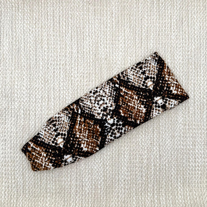 Flat, stretchy headband with brown snakeskin print.