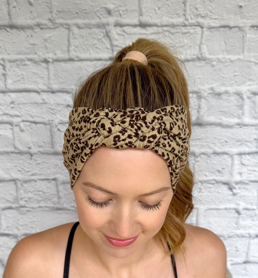 Woman with hair in ponytail wearing a sailor knot style headband with ribbed fabric in brown with black cheetah print.