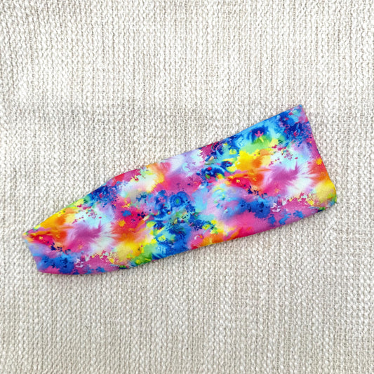 Flat, stretchy headband in rainbow splatter print.