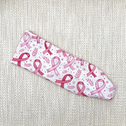 Flat, stretchy headband with pink ribbon, leaf, and polka dot print.