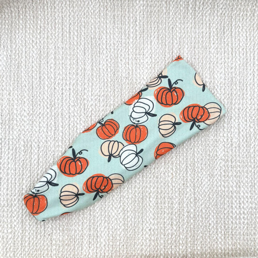 Flat, stretchy, mint green headband with pumpkin print.