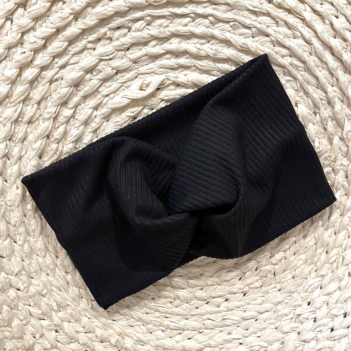 Wide, twisted headband in black ribbed print.