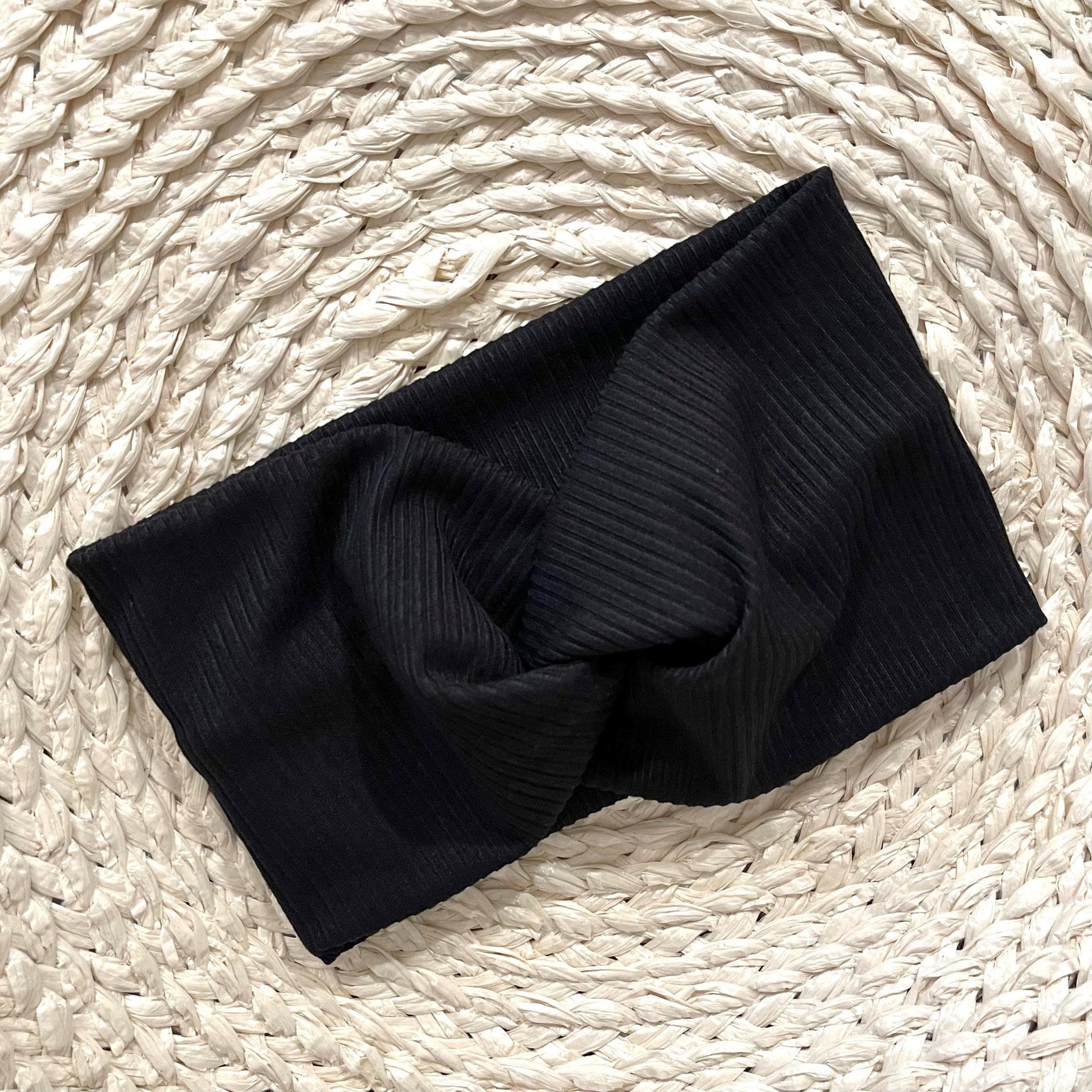 Wide, twisted headband in black ribbed print.