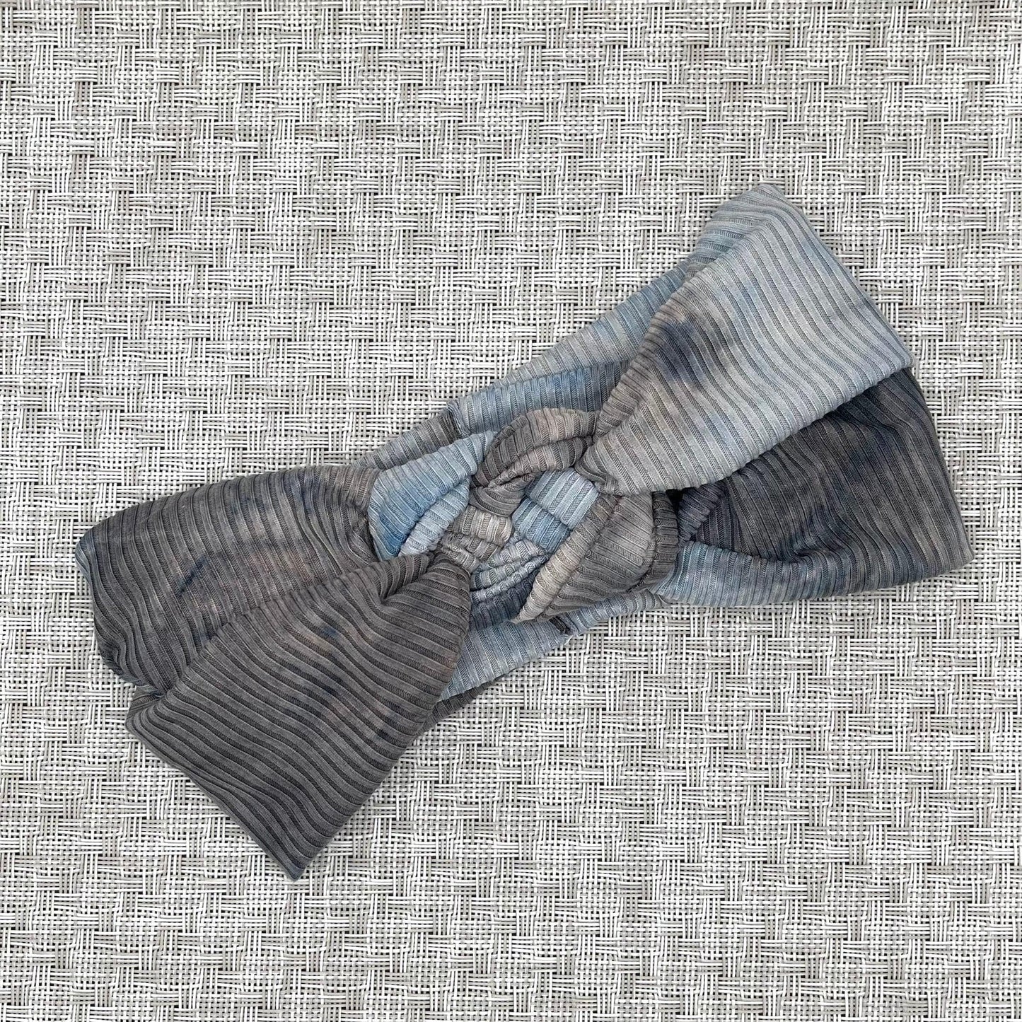 Sailor knot style headband in ribbed fabric with gray and blue tie dye print.