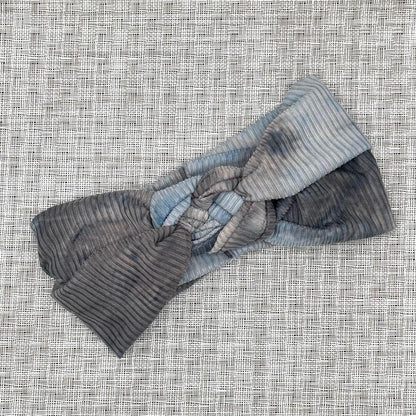 Sailor knot style headband in ribbed fabric with gray and blue tie dye print.