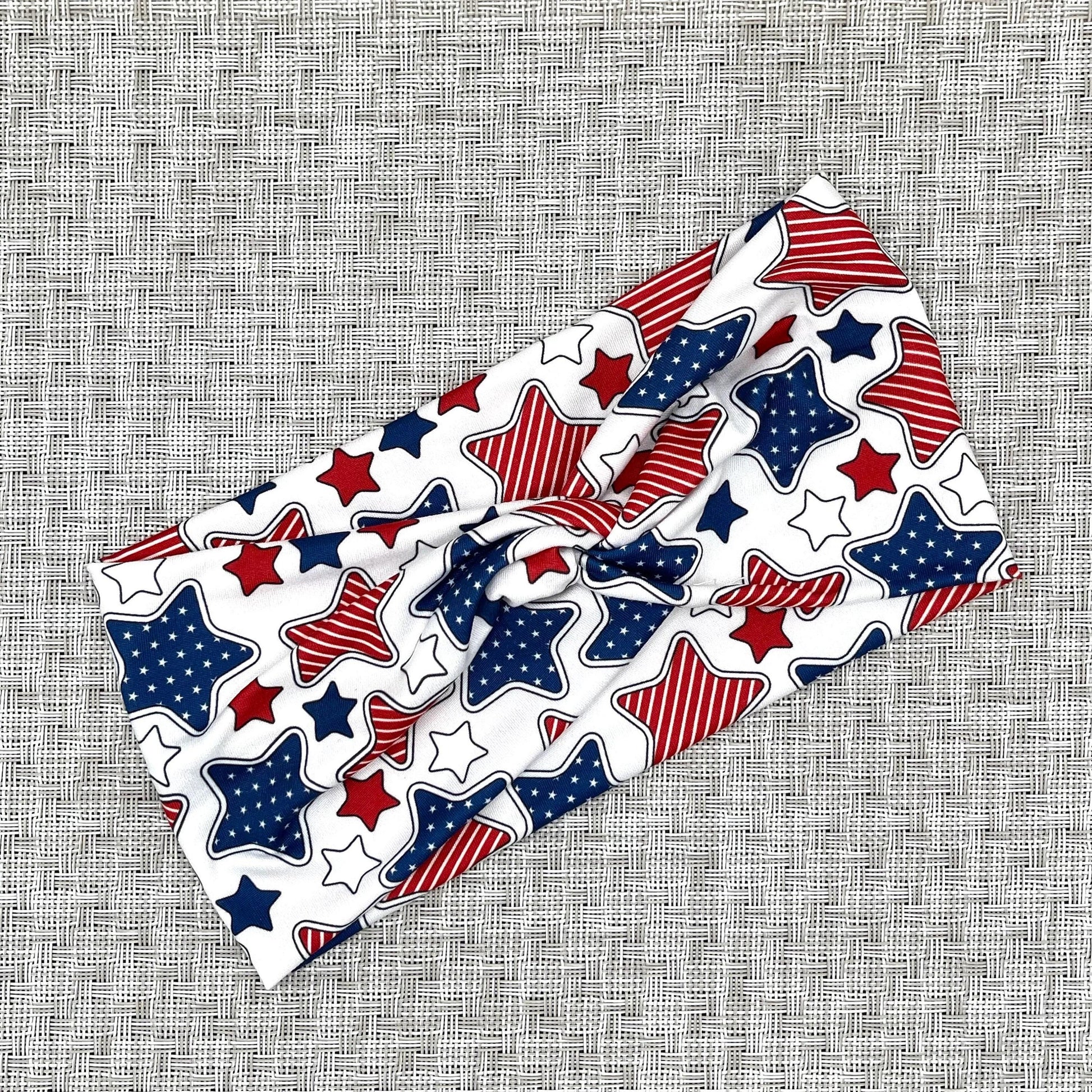 Wide, twisted headband in white with red, white, and blue star print.