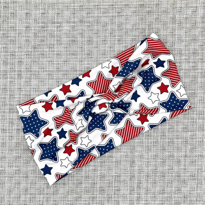 Wide, twisted headband in white with red, white, and blue star print.