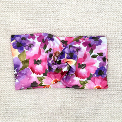 Wide, twisted, stretchy headband with purple floral print.