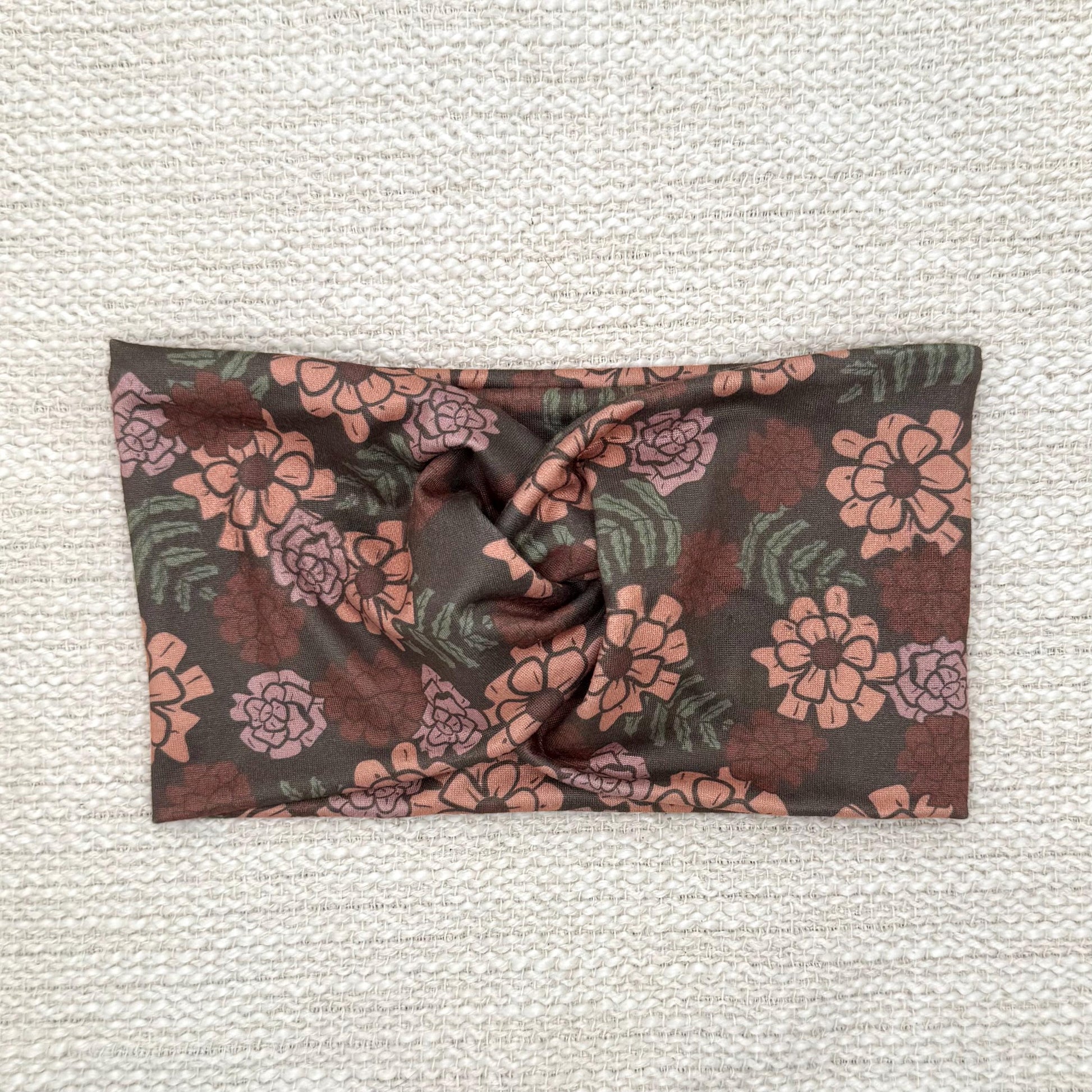 Wide, twisted headband in gray/brown with peach color floral print.