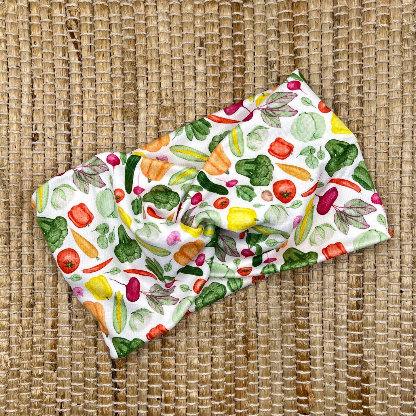 Wide, twisted headband in white with vegetable theme print.