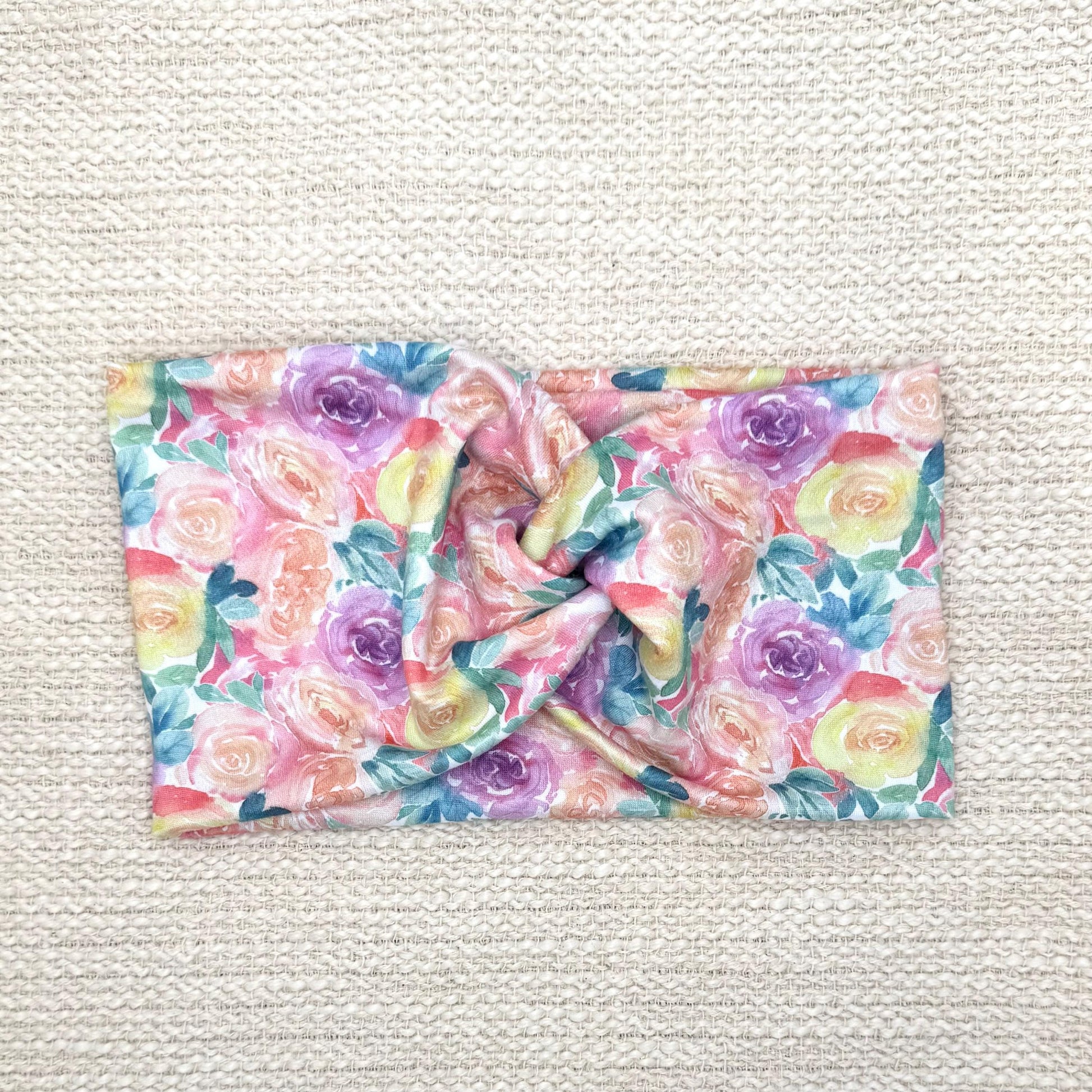 Wide, twisted headband in pastel color rose print.