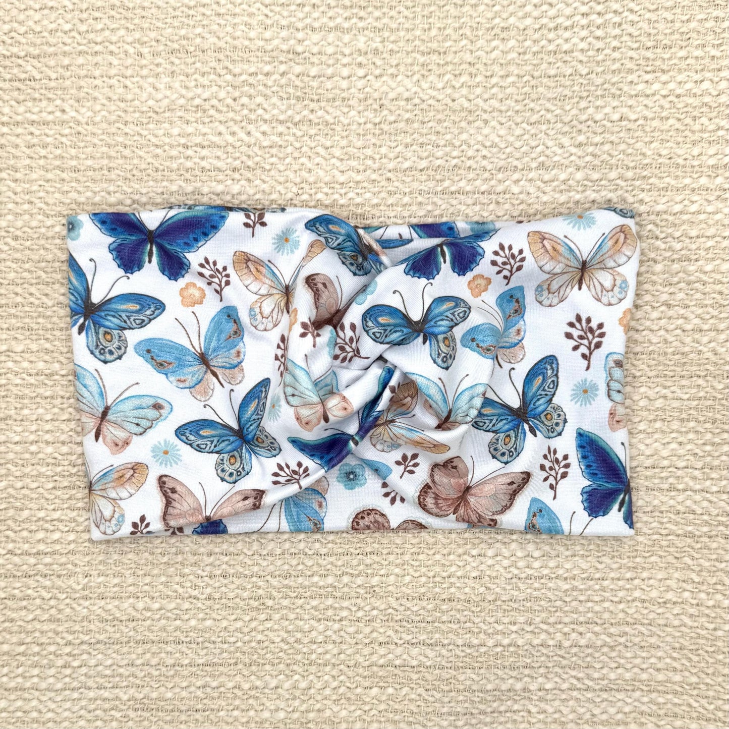 Wide, twisted headband in white with butterfly print.