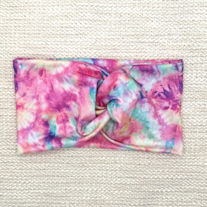 Wide, twisted headband with pink and multicolor tie dye print.