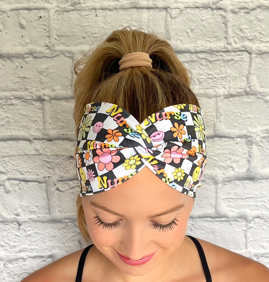 black and white checker print wide twist headband with "nurse" print and flowers in rainbow colors